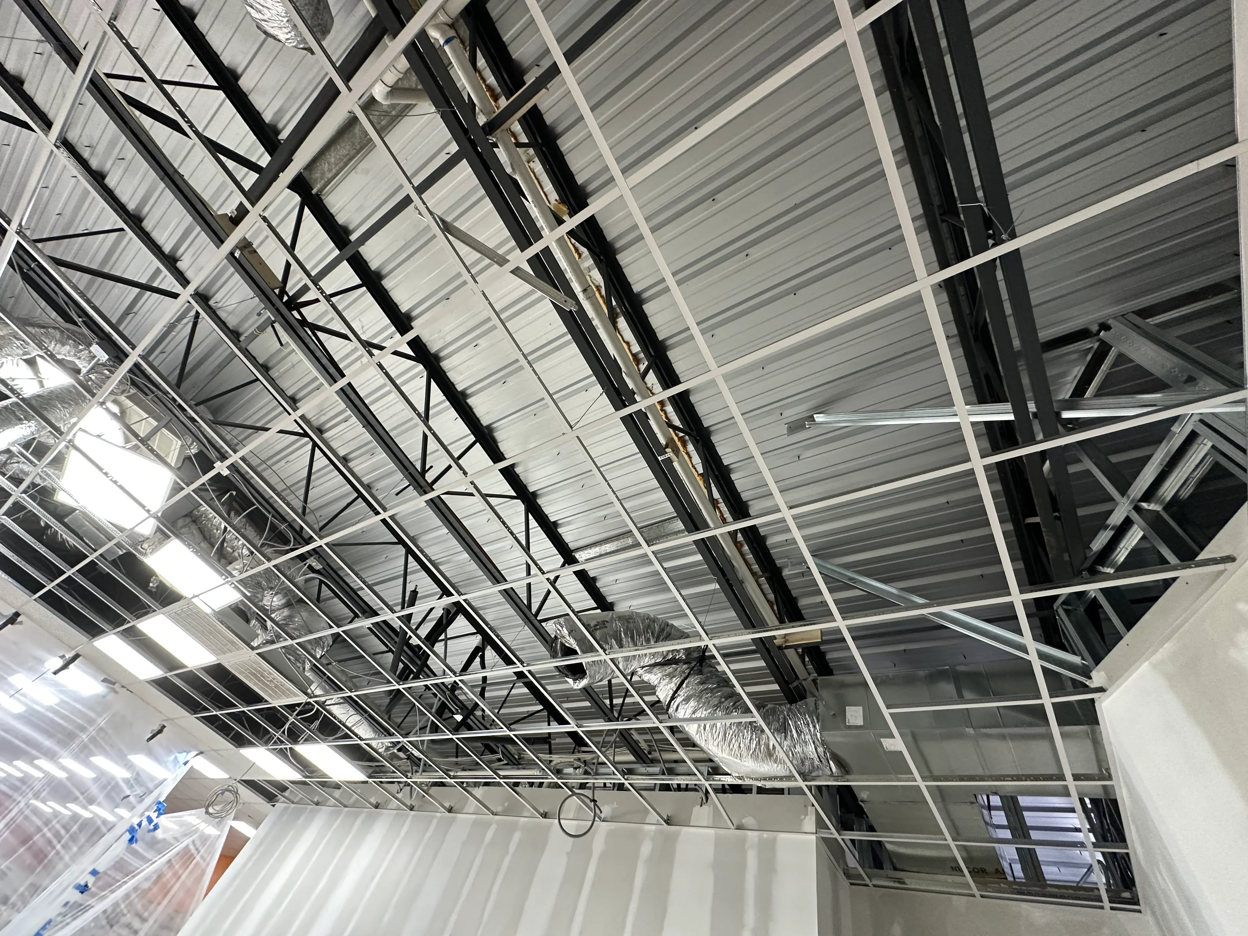 Metal stud framing with steel beams and corrugated metal decking in commercial interior