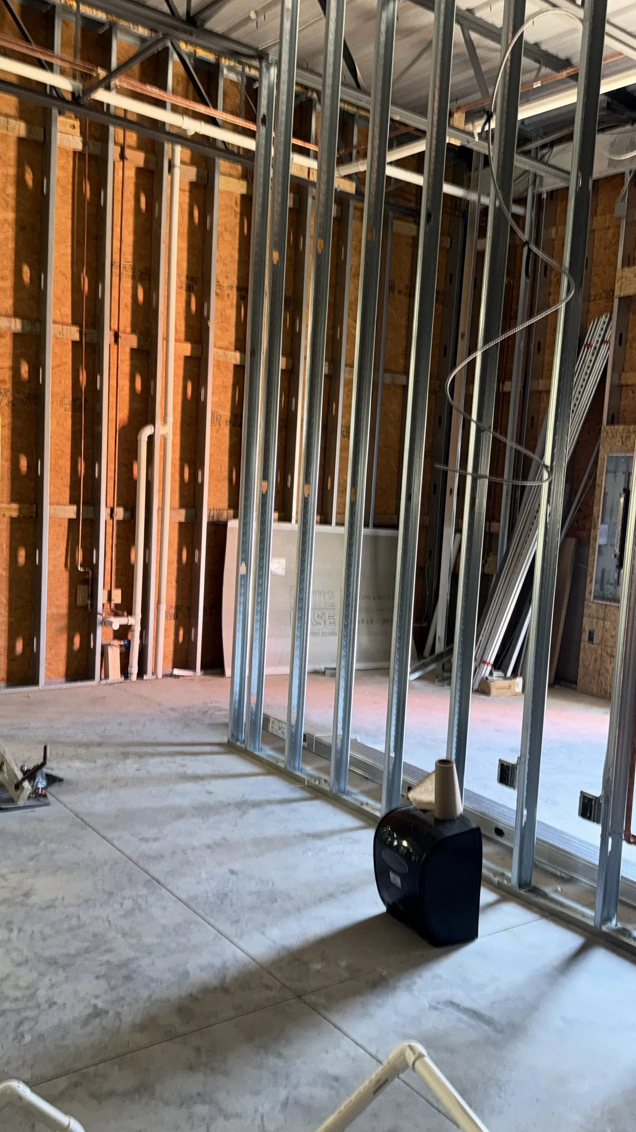 Steel stud framing with horizontal bracing and electrical wiring in multi-story interior construction