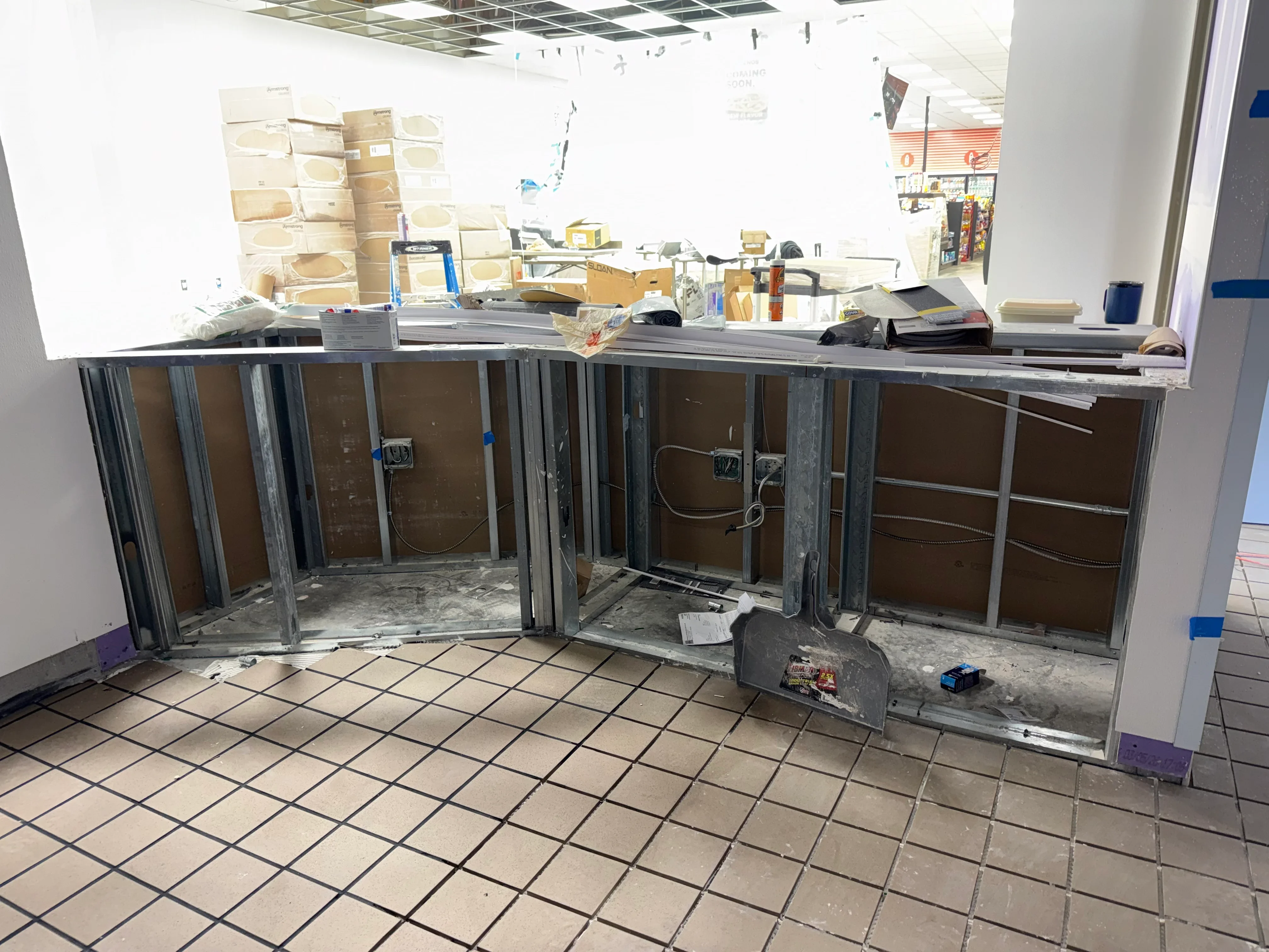 Steel stud framing with electrical rough-in and outlet boxes in commercial interior space