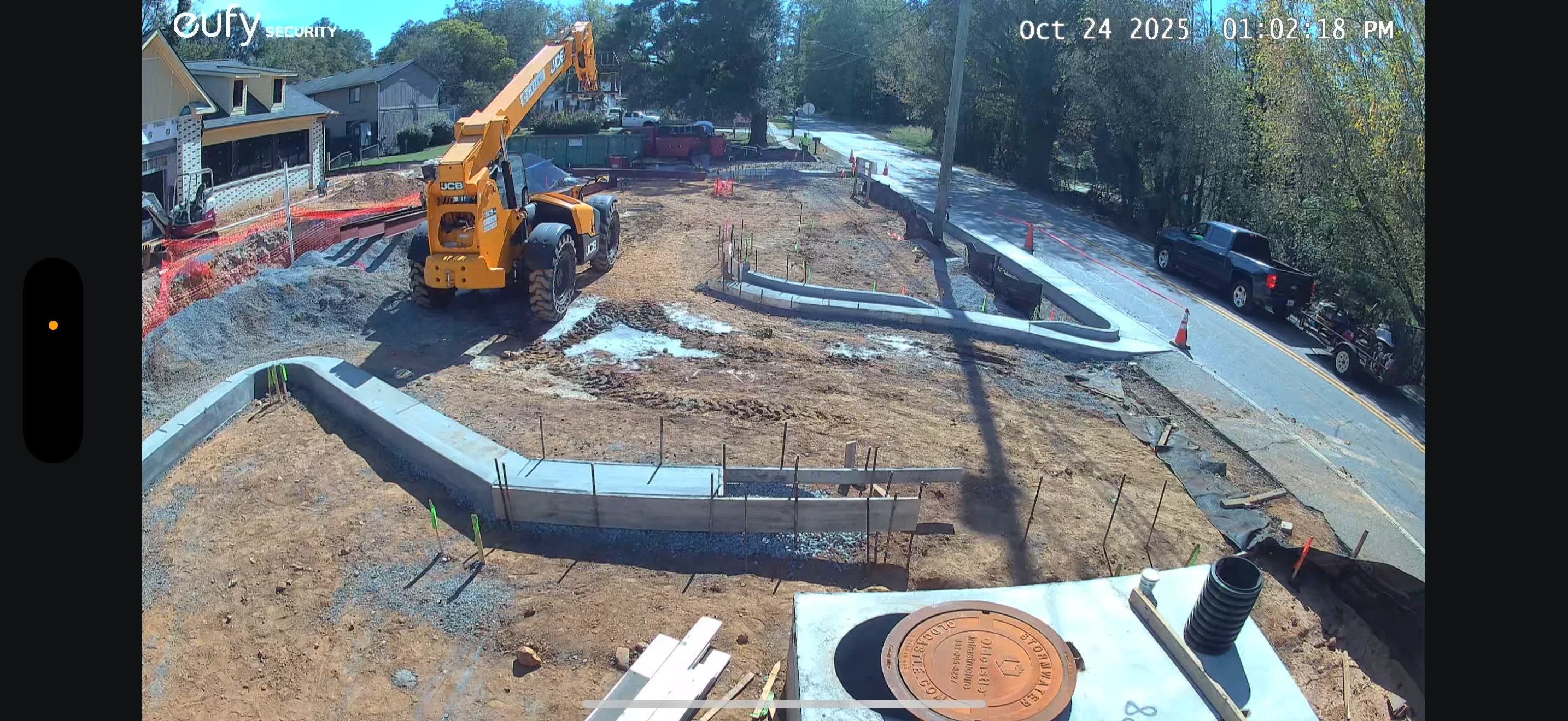 Concrete foundation footers with rebar, excavated site, and heavy equipment during residential construction