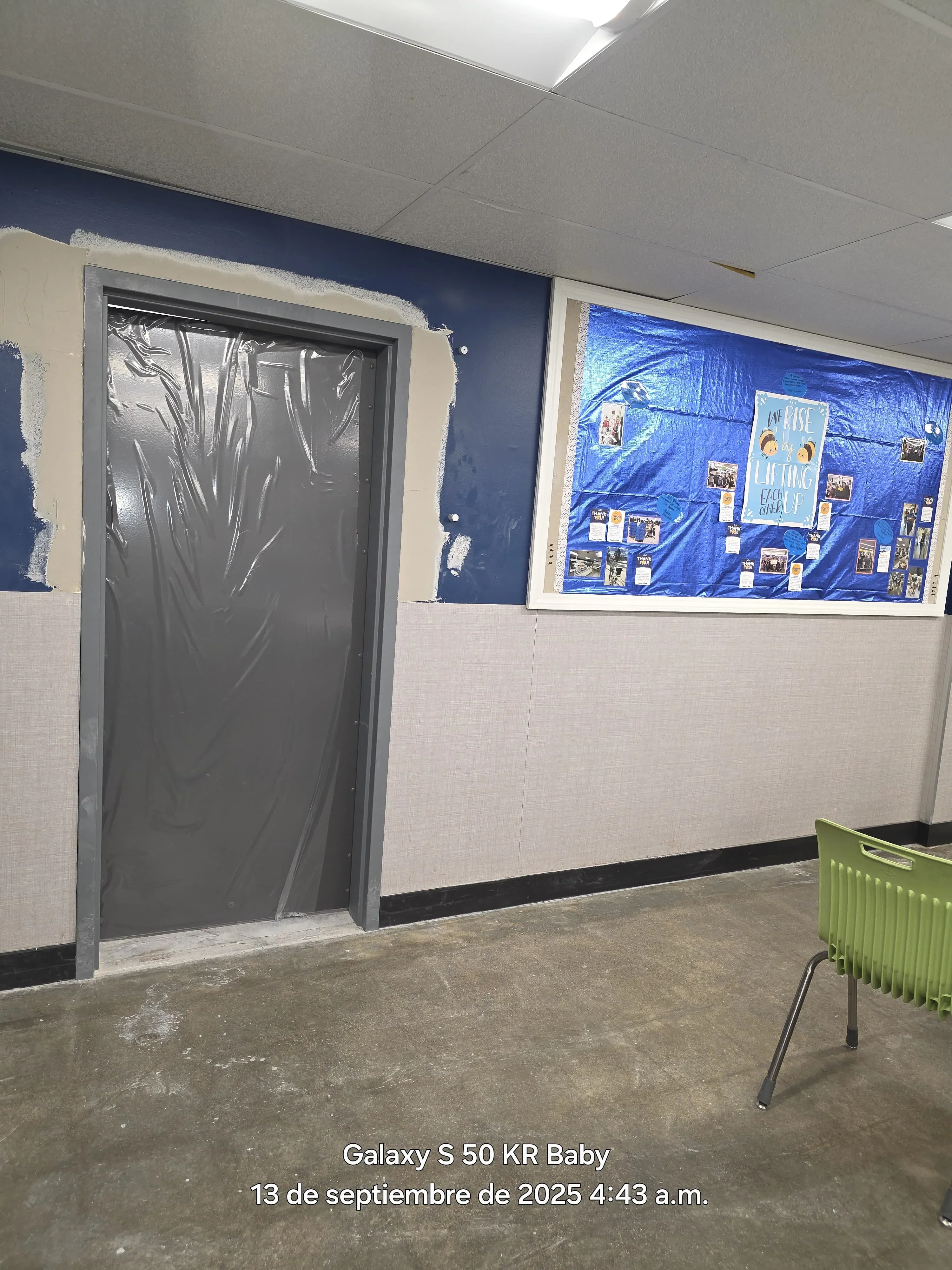 Interior room with navy blue upper walls, cream lower walls, and protected door frame during painting project