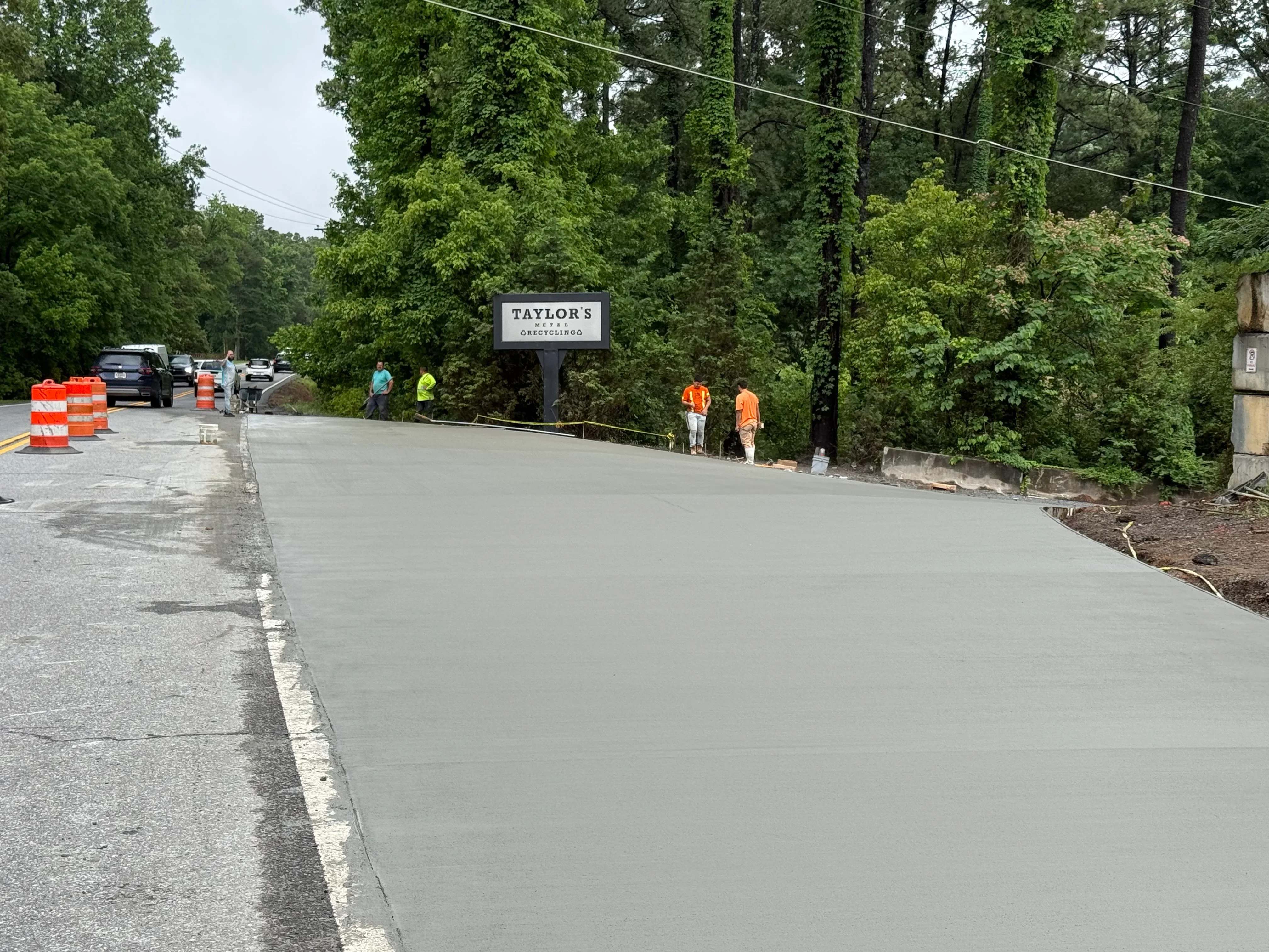 Newly poured concrete parking lot with smooth gray finish and white edge line marking